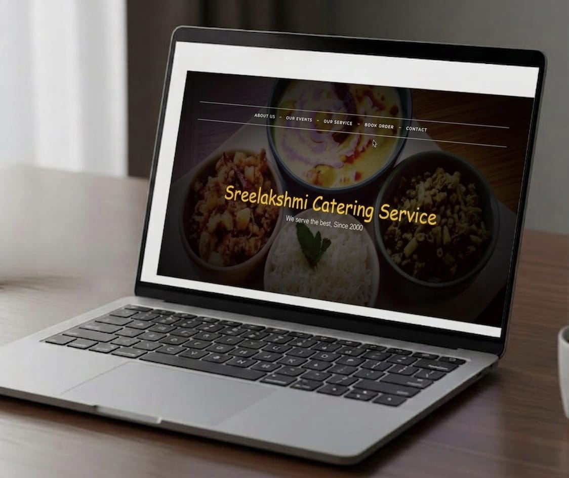 Laptop screen displaying the homepage hero section of the Sreelakshmi Catering Service website, featuring the brand name and the tagline "We serve the best, Since 2000" overlaid on images of traditional South Indian dishes.