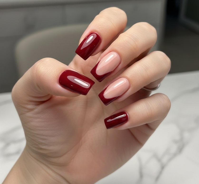 Close-up of a professional manicure with glossy red and nude gel nail polish in a modern nail salon